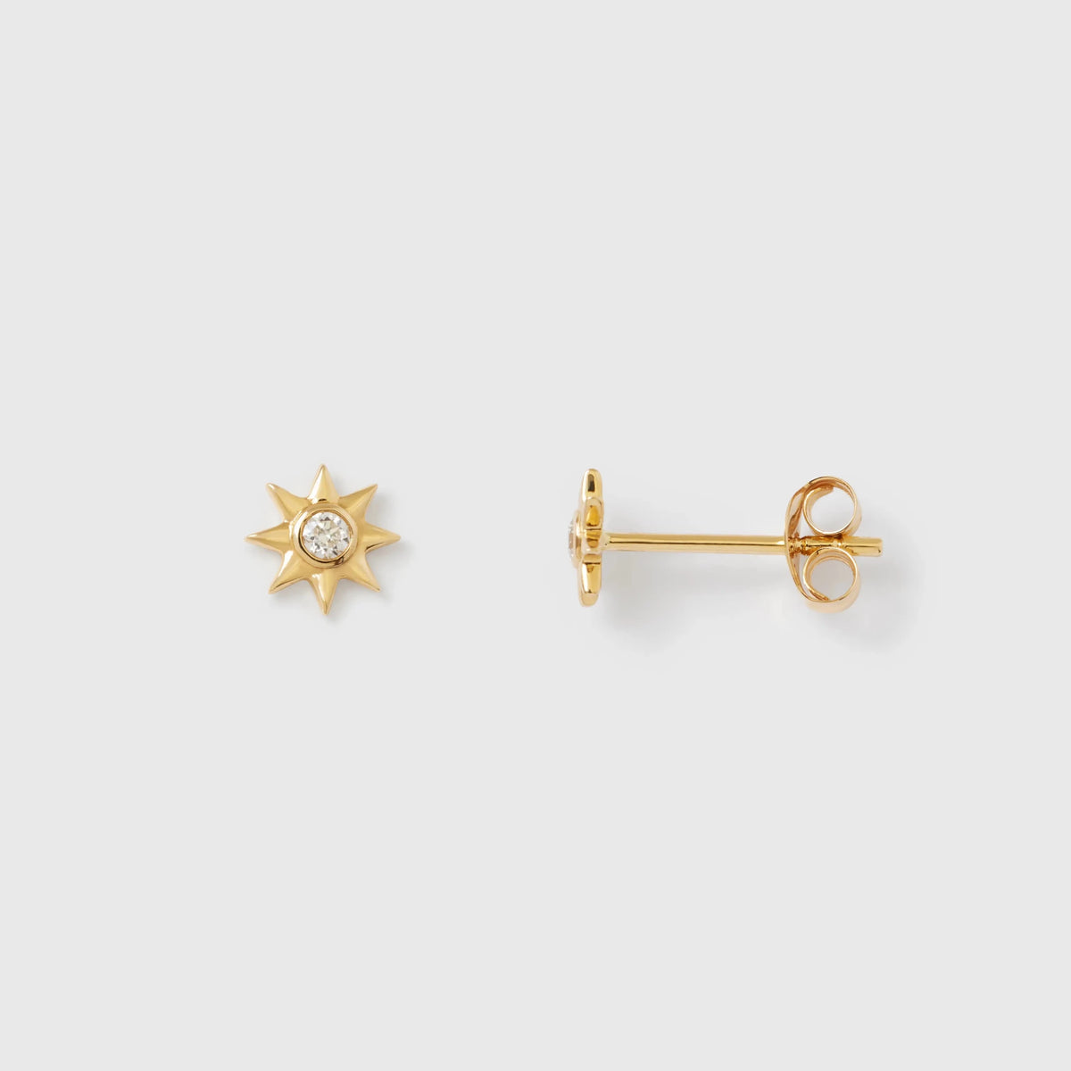 Sternförmige Ohrstecker aus glänzendem Echtgold mit jeweils einem zentral gefassten, funkelnden Diamanten vor hellem Hintergrund.