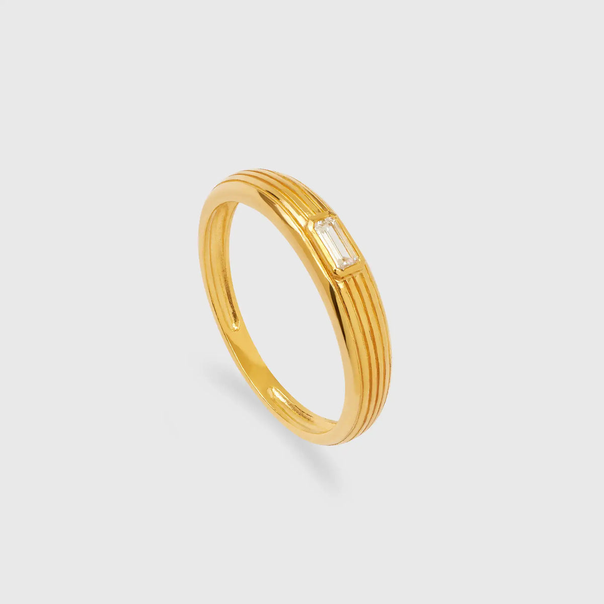 Vergoldeter fejn Sparkle Riffle Ring mit geriffelter Struktur und einem rechteckigen, weißen Zirkonia Stein.