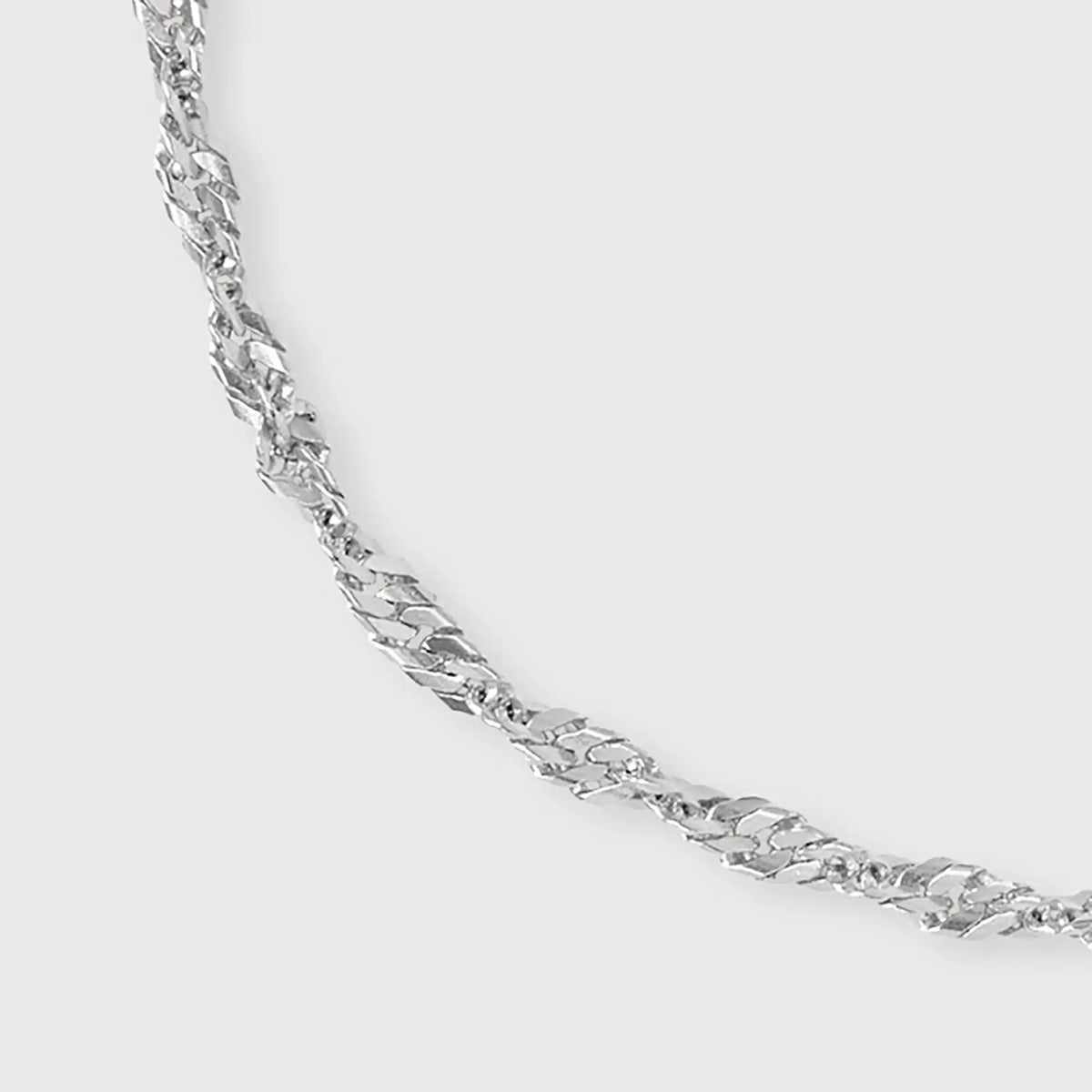 Detailaufnahme unseres gedrehtem Gliederarmband in Silber mit fejn Logo-Plättchen vor weißem Hintergrund