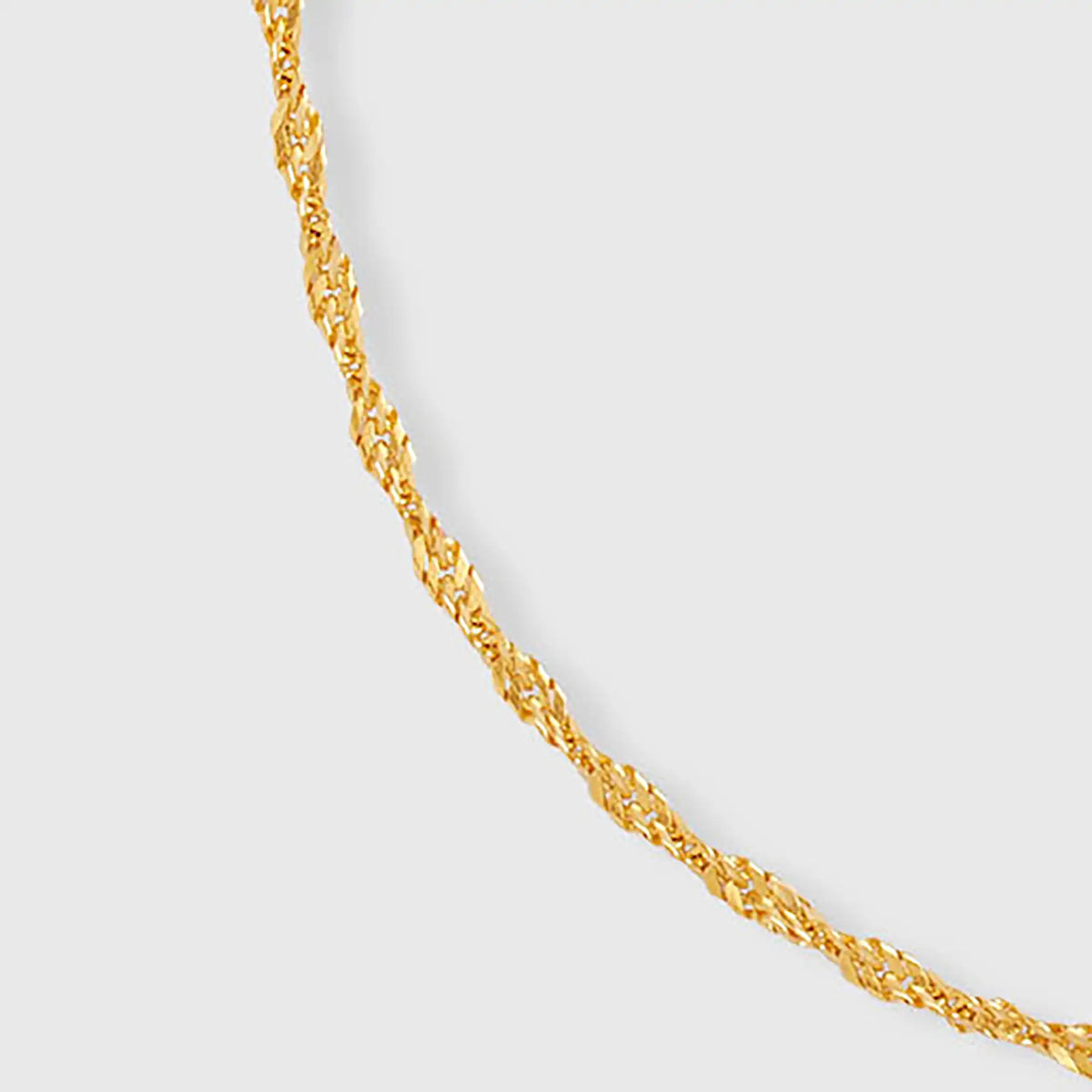 Detailaufnahme unseres gedrehtem Gliederarmband in Gold mit fejn Logo-Plättchen vor weißem Hintergrund