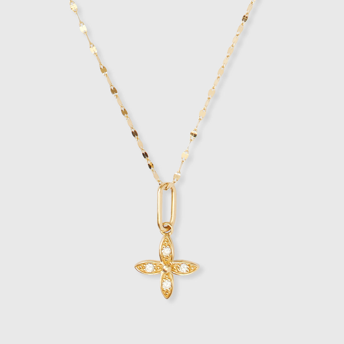 Goldener Kettenanhänger in Blumenform aus Echtgold mit funkelnden, gefassten Diamanten an einer feinen Ankerkette vor hellem Hintergrund.