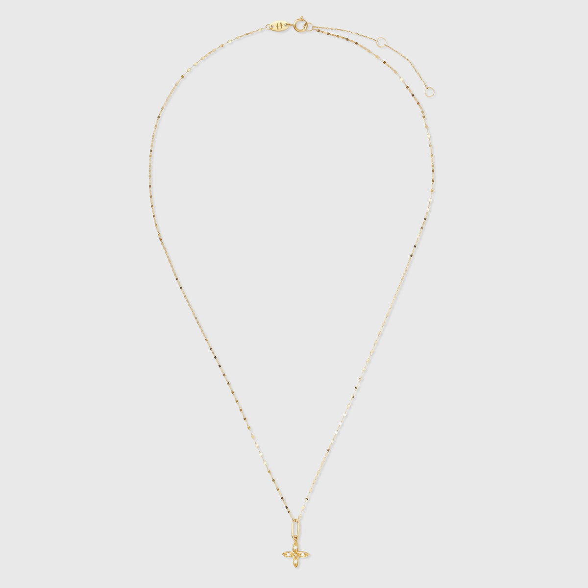 Goldener Kettenanhänger in Blumenform aus Echtgold mit funkelnden, gefassten Diamanten an einer feinen Ankerkette vor hellem Hintergrund.