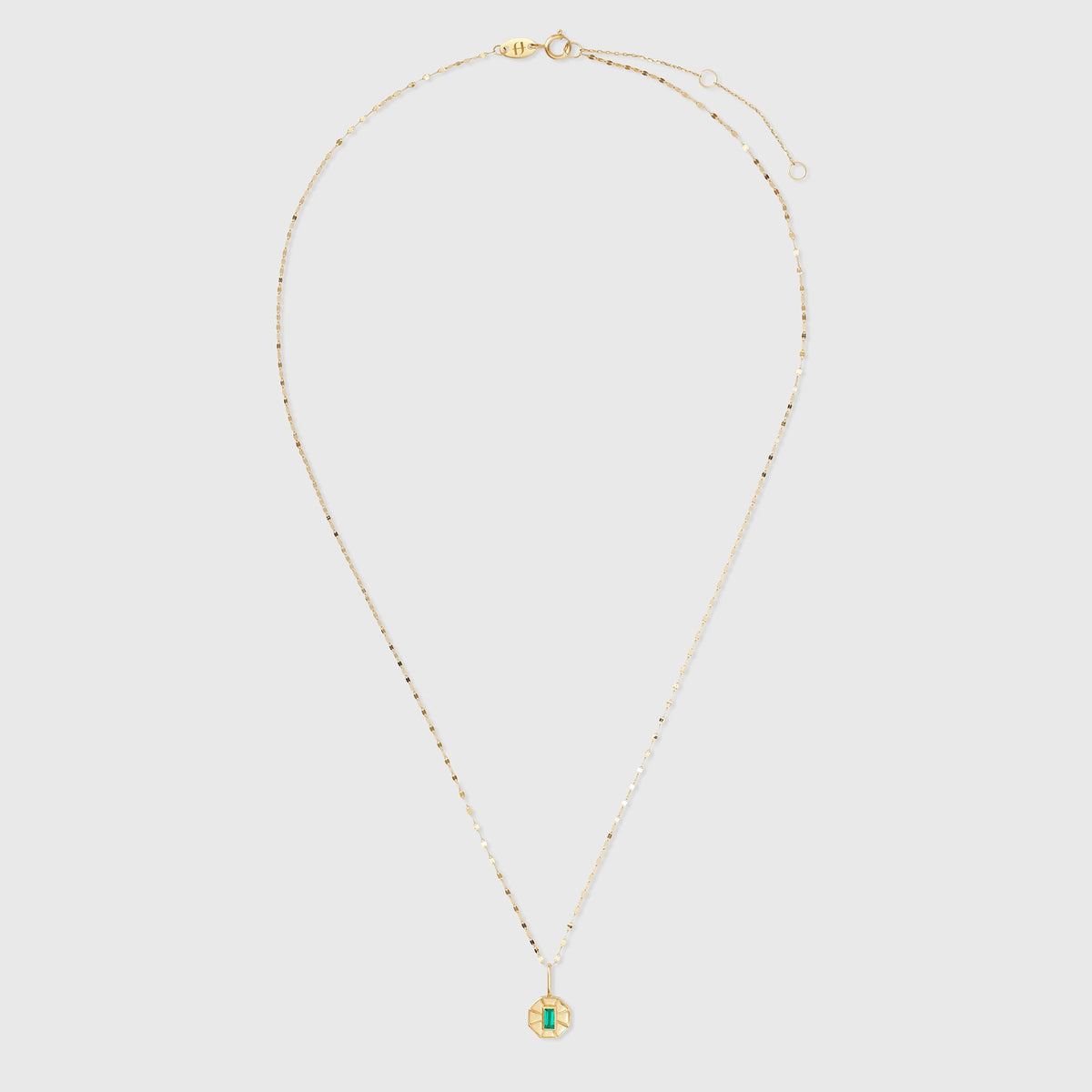 Filigrane Goldkette mit einem achteckigen Kettenanhänger aus glänzendem Echtgold mit einem rechteckigen, grün leuchtenden Edelstein im Art-Déco-Stil.