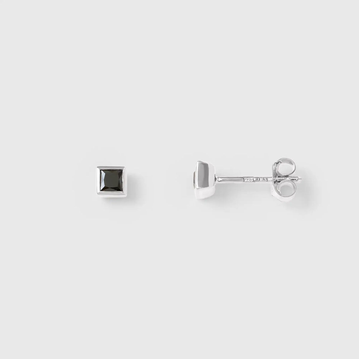 Schlichter eckiger Silber-Ohrstecker mit einem quadratischen schwarzen Zirkonia Stein, vor weissem Hintergrund, von fejn jewelry.