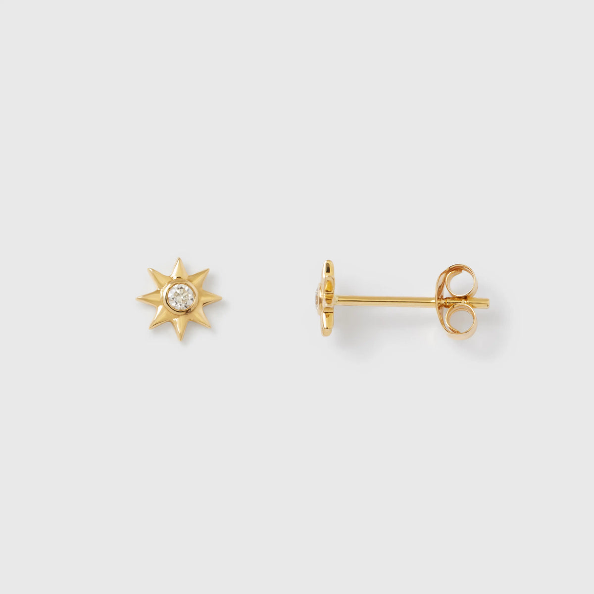 Sternförmige Ohrstecker aus glänzendem Echtgold mit jeweils einem zentral gefassten, funkelnden Diamanten vor hellem Hintergrund.